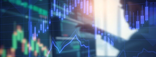 Ein Geschäftsmann sitzt vor den Monitoren an der Börse