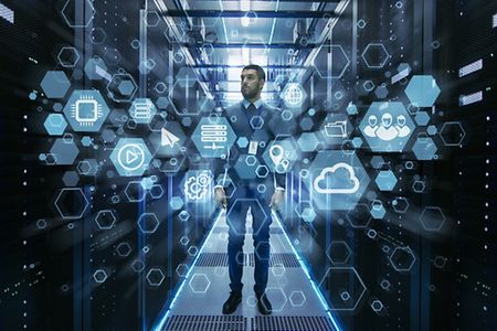 Mann steht in Serverraum und Digitalisierungssymbole sind um ihn herum.