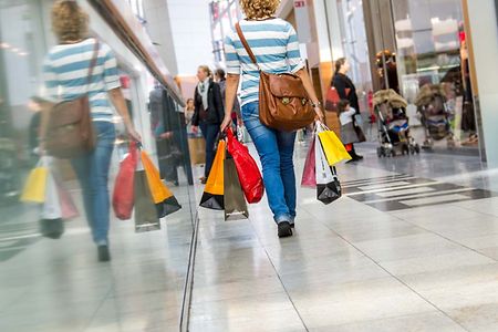 Image Einzelhandel: gehende Frau mit Einkaufstüten nach dem Shopping im Einkaufszentrum