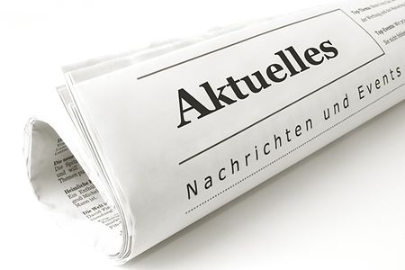 Zusammengerollte Zeitung, darauf steht "Aktuelles"